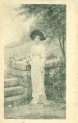 Femme à la campagne adossée à un muret en pierre