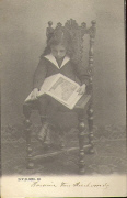 Petite fille lisant un livre sur une chaise