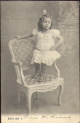 Petite fille assise sur l'accoudoir une chaise