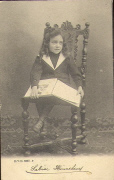 9. Petite fille lisant un livre sur une chaise