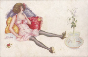 Femme en nuisette allongée sur des coussins devant bocal à poissons rouges