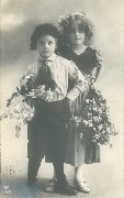 Deux enfants garçon et fille en tenue de cérémonie portant des branches de fleurs