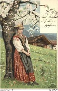Femme en costume régional adossée à un arbre